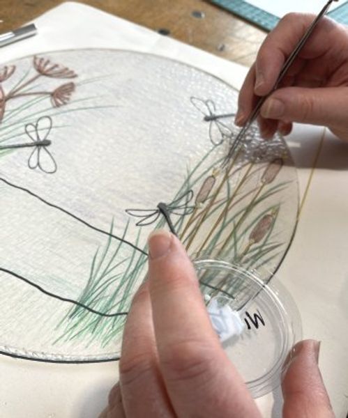 Carefully placing frits, enamel pen work and stringers to create your image