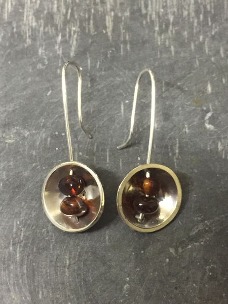 A pair of domed amber bead earrings made by a student
