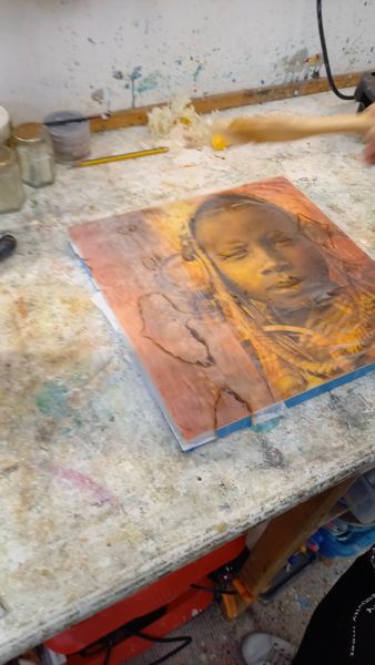 A students tribal portrait layered and textured under encaustic wax.