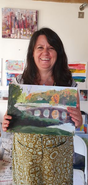 Jeanette is holding her finished acrylic painting of the landscape at Stourhead.