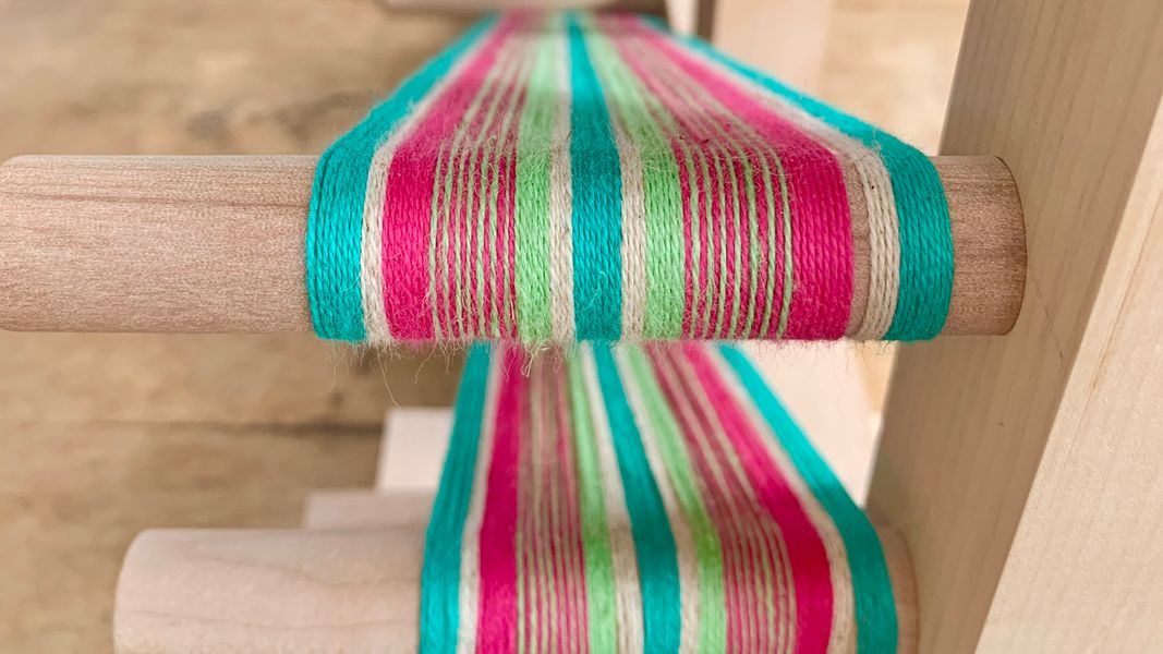 A band being woven on an inkle loom in organic cotton and linen