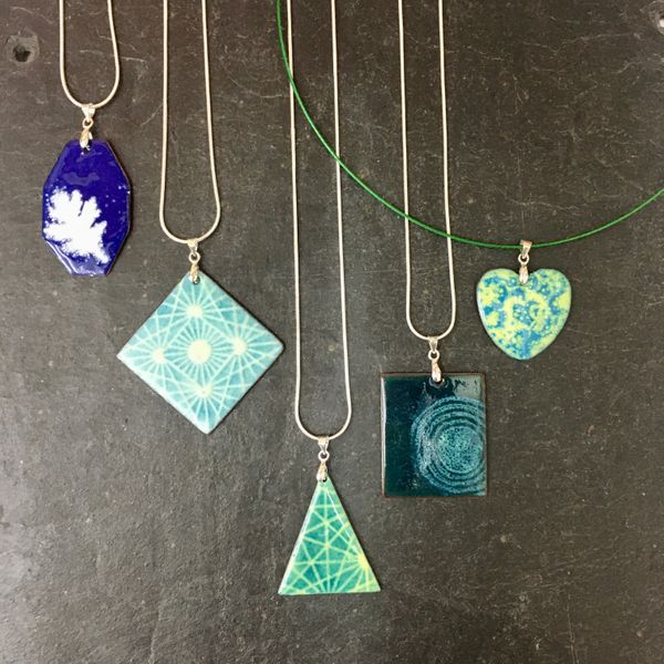 Enamelled pendants ready to wear home, made at Rainbow Glass Studios!