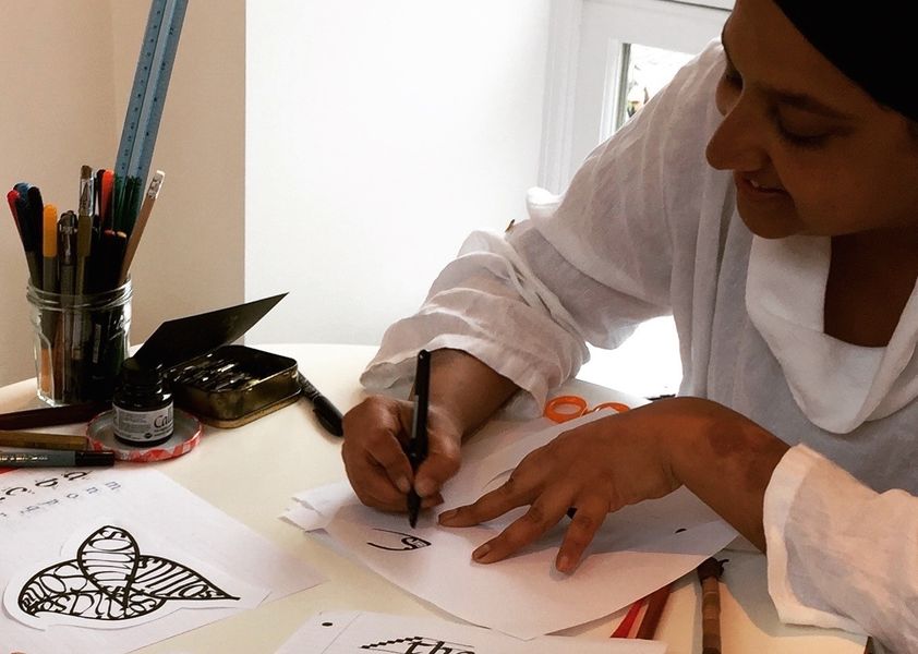 Artist Panna provides hands-on help on The Arienas Collective calligraphy classes in Edinburgh.