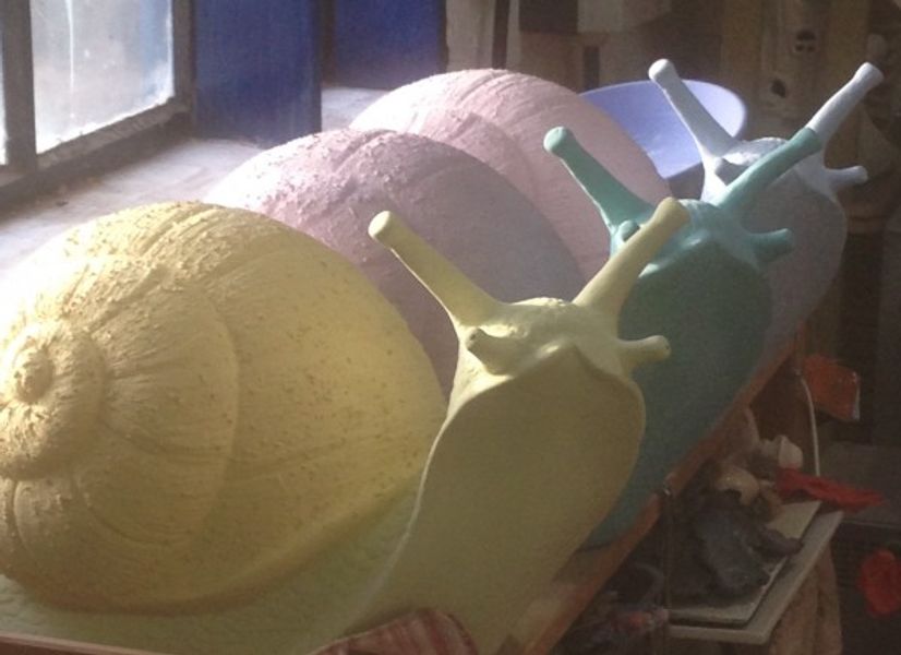 Painted giant pottery snails patiently waiting to be fired at Saz's Ceramics in Wordsley