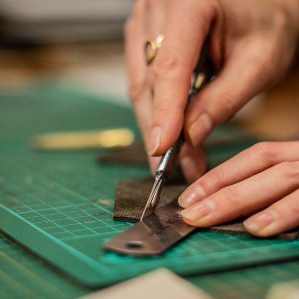 Cutting leather using a ruler and scalpel