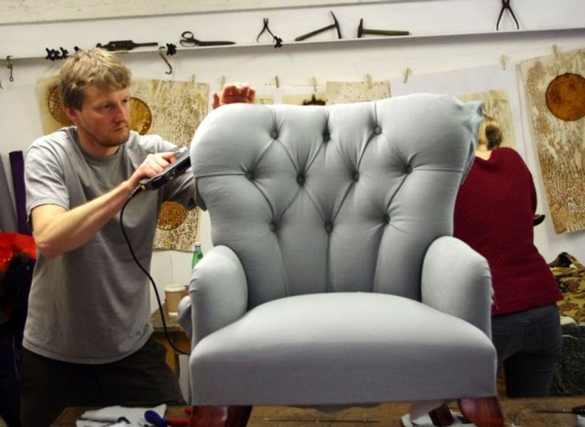 Student working on deep-buttoned modern upholstered armchair