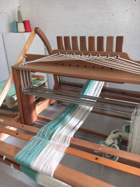 Threading up the table loom for a weaving techniques demonstration