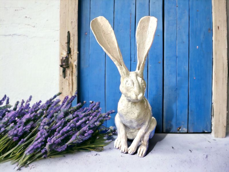 Ears up hare in front of blue door with lavender