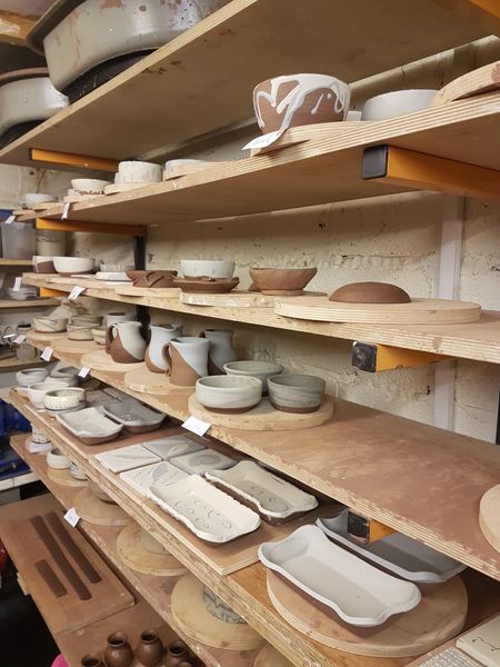 Lots of pots drying on the shelves waiting for their first firing.