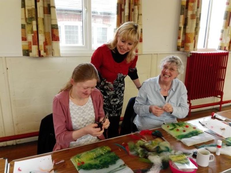 Raya is teaching her adult learners how to paint with wool fibres