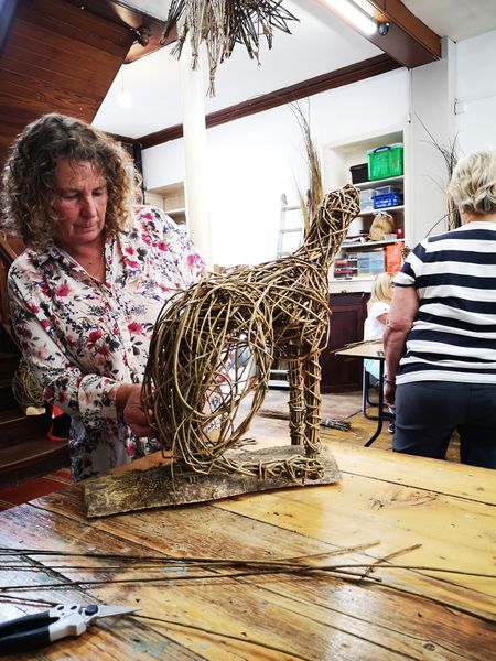 student weaving willow hare