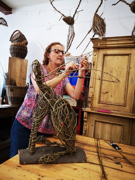 student weaving willow hare