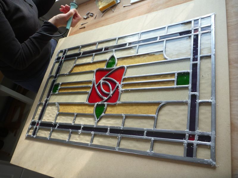 If you come for weekly stained glass classes in Kent, you can make windows for your house. The lady making this one is making two others too.