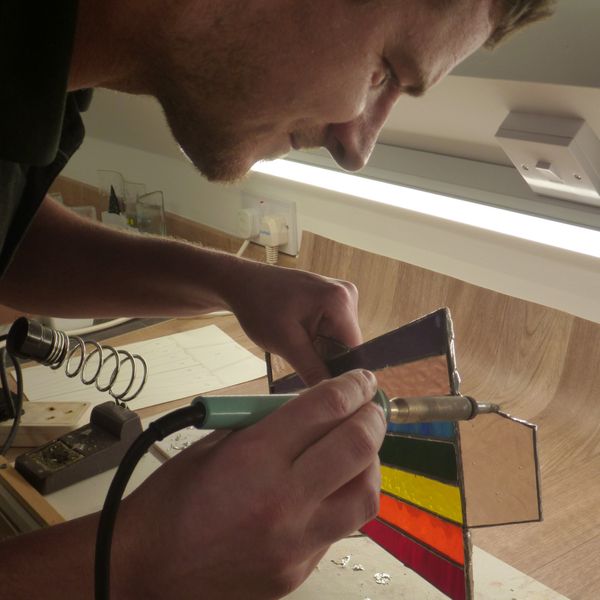 Alex finishes soldering his first ever copper foiled stained glass.