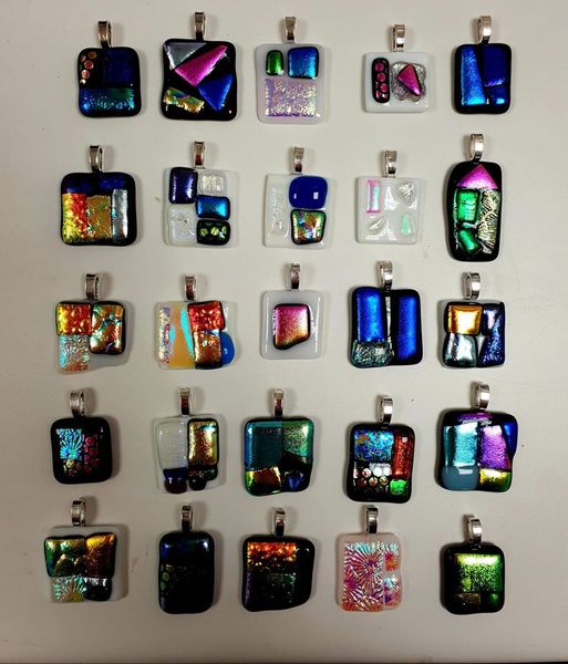 Examples of dichroic glass jewellery.  Pendants made by workshop guests.