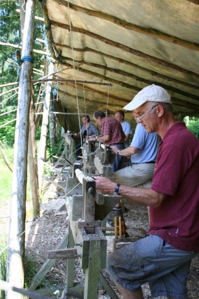 A line of pole lathes with people turning parts for their chair.