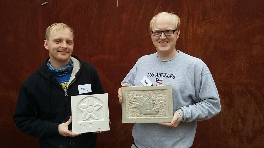 Proud sculptors displaying their masterpieces