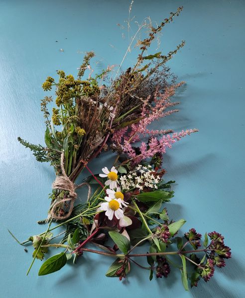 Bunch of flowers, grass and leaves for creating a floral silver clay pendant.