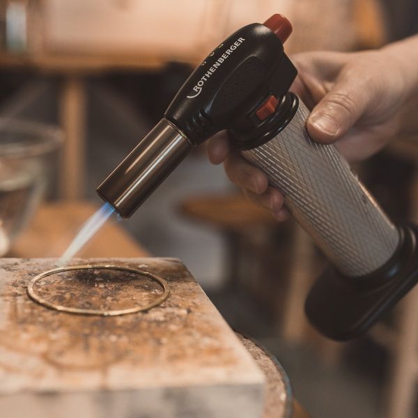 A student annealing their metal ready to hammer it into shape