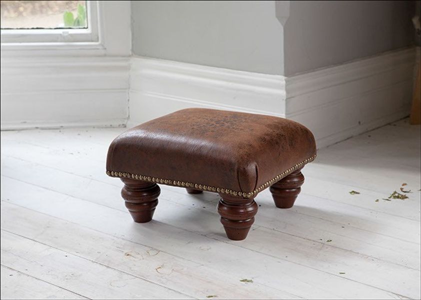 A very cute faux leather footstool with chunky legs