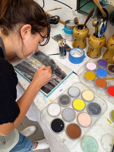 A student working with pan-pastels on the surface of her panel.