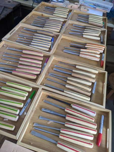 Colour coded sets of chisels in wooden trays