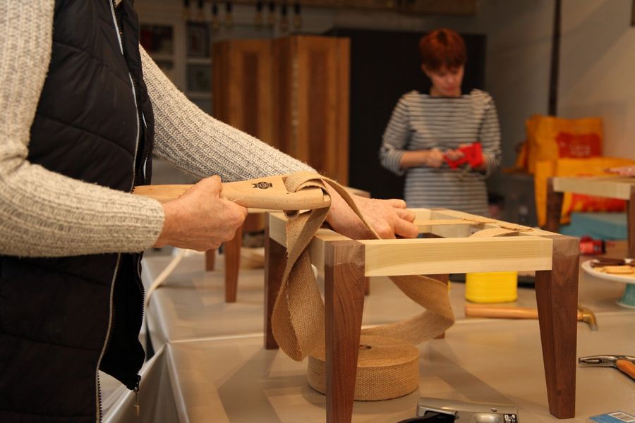 Learning to use a 'web stretcher' an upholstery tool