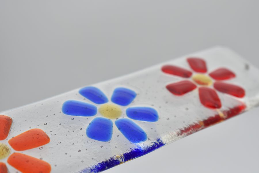 Colourful stylised flowers on a fused glass suncatcher