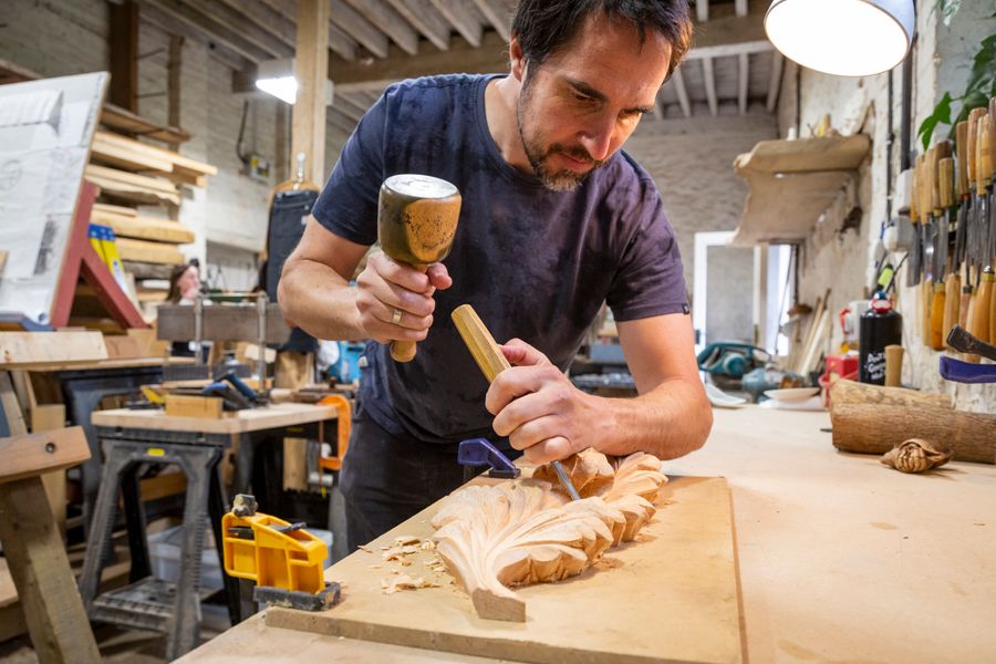 Course tutor carving a leaf design in wood