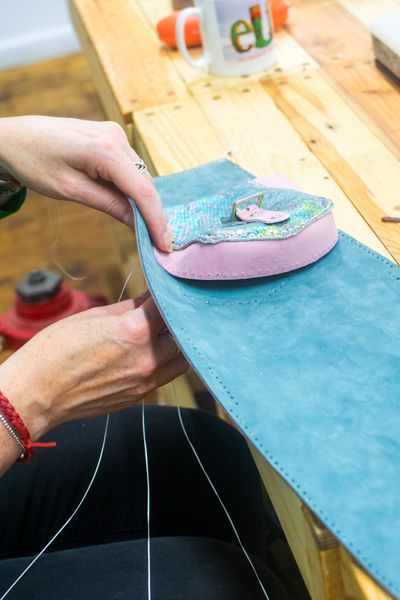 A student attaching the pocket to their satchel