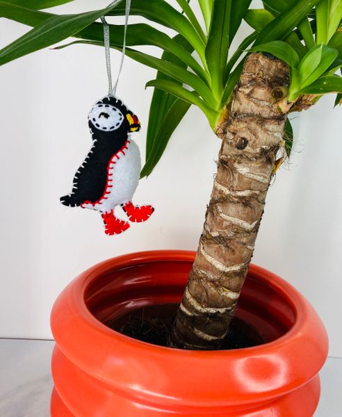 Felt puffin ornament hanging from houseplant