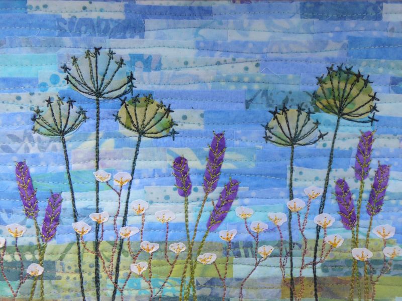 A light and bright Summer's day in a warm flower meadow. The background is pieced batik fabrics with applique flowers and sewn details.