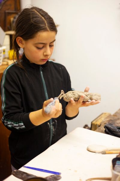 Child making animal in clay