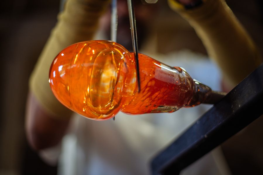 A student learning to make the crucial 'neck line' in a bubble of hot glass.