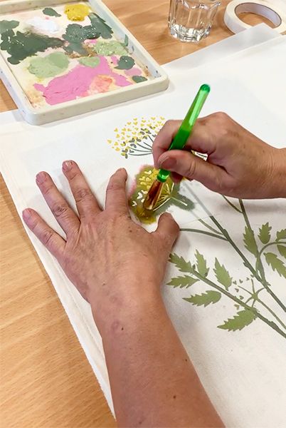 Fabric stencil paint being applied with a brush to build the design