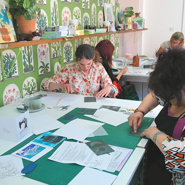 workshop students cutting a lino design