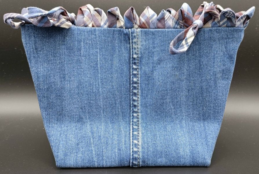 Gift bag made from denim with a decorative top.