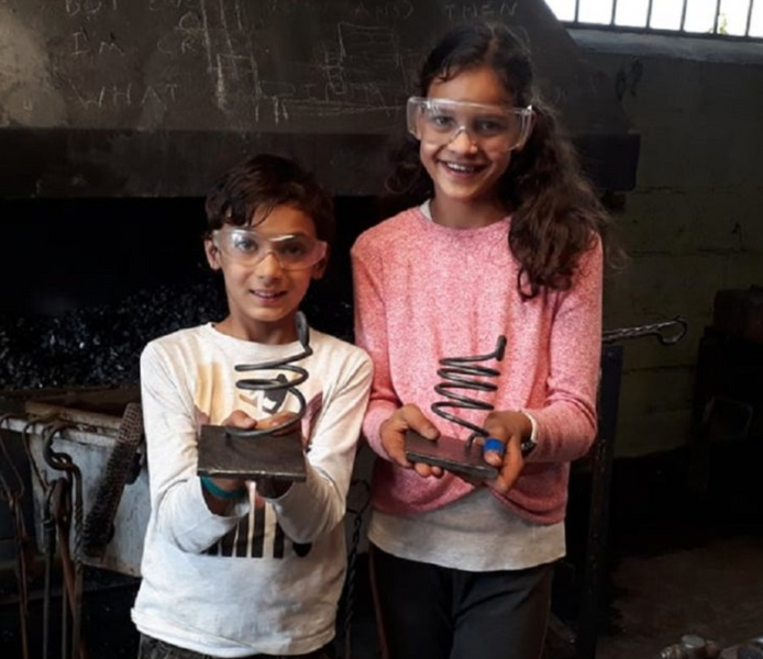 Children experiencing the blacksmith's forge