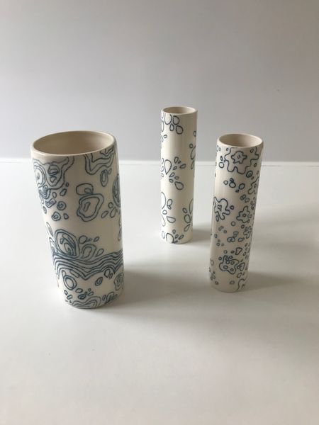 Underglaze pencil decoration on a set of slipcast vases