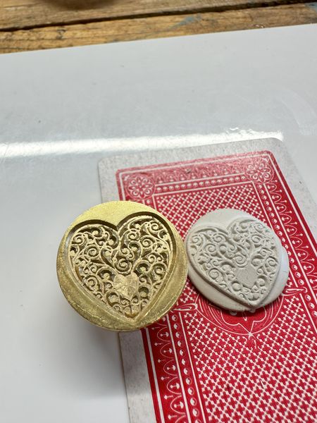 Work in progress - the brass stamp and the silver metal clay before firing