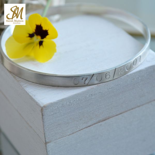 Flat SterlingSilver bangle with text.