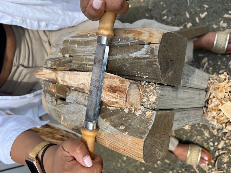 A draw knife being used to carve a spoon