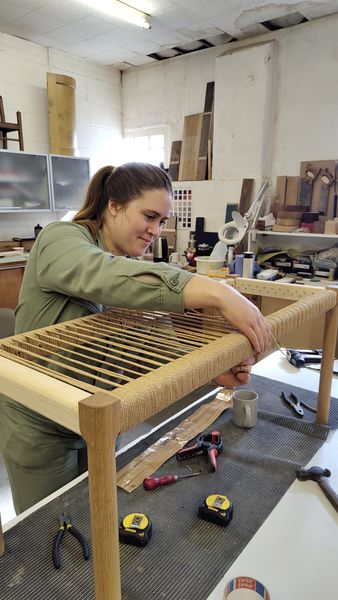 Student weaving a Danish bench on lee furniture weaving course.