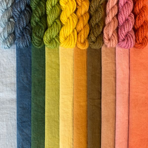 A spectrum of naturally dyed cotton fabric and wool skeins.